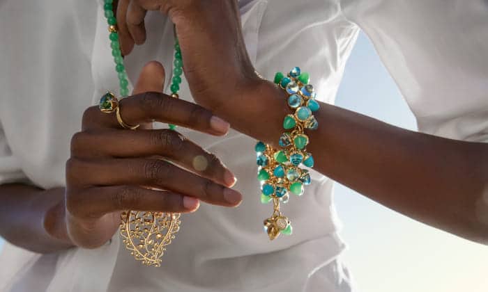 Primer plano de pulsera Mikado de Tamara Comolli en tonos azules y verdes, con detalles dorados, acompañada de collar y anillo