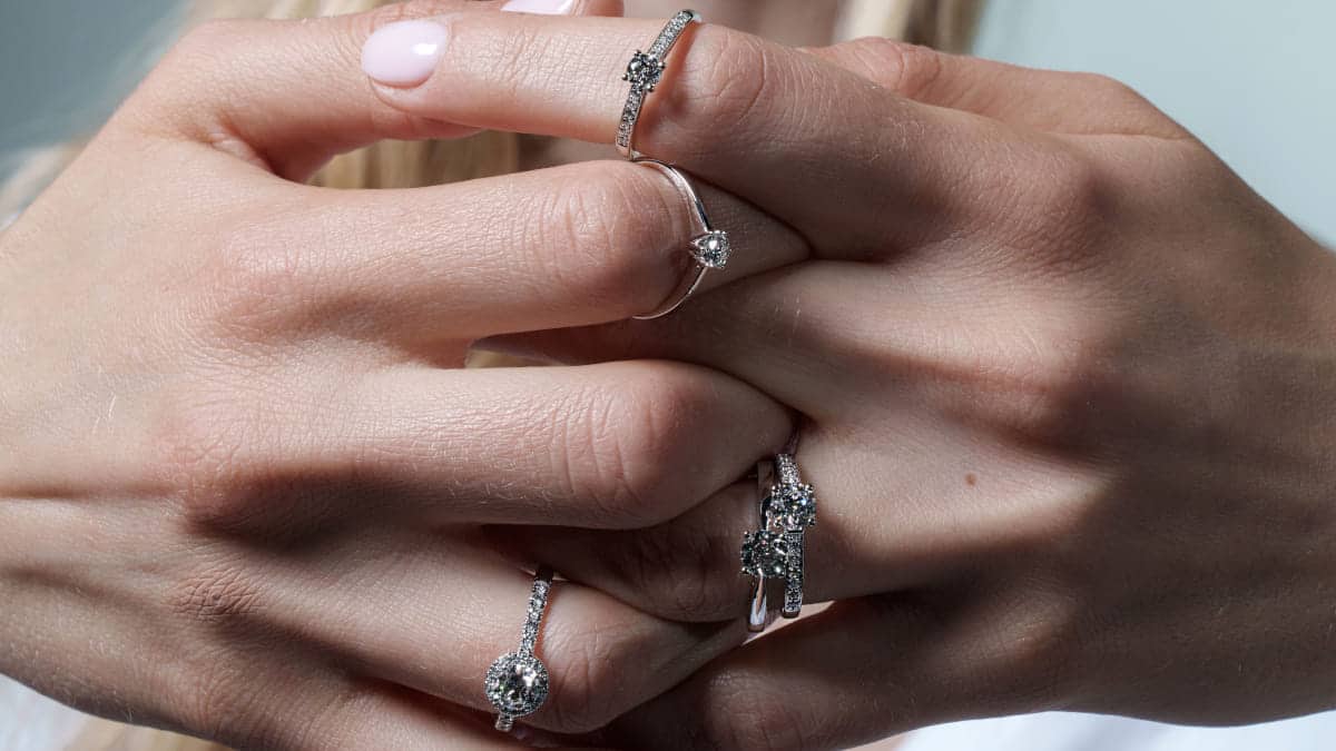 mans amb anells de compromís de la marca maison roca, en or i diamants