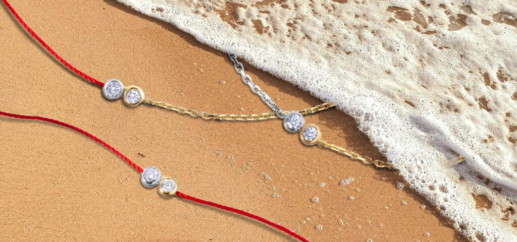 tres braçalets amb diamants a la sorra de la platja